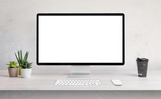 Computer display on work desk with white, isolated screen for web page presentation photo