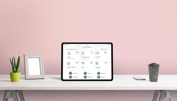Tablet with smart home app on home desk. Concept home automatization app with important home devices control photo