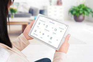 Home devices control on modern smart home app on tablet display in woman hand concept