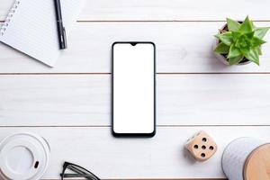 Phone mockup on white wooden work desk. top view composition. Isolated display for app design presentation photo