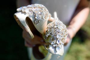 zapatos de boda en manos de novias foto