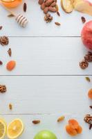 Apples, kiwi fruits, dried fruits, oranges and apples. Healthy eating concept. Shot on a white wooden table. photo