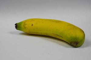 one yellow banana on a gray background photo