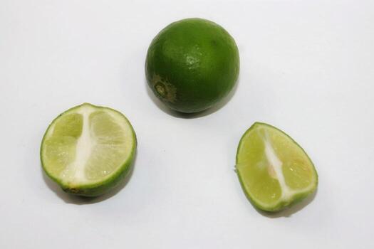 limes are green and some have been split on a gray background photo