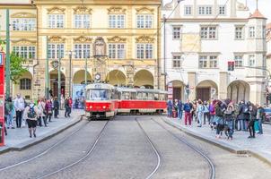 Typical old retro vintage tram on tracks near tram stop in Prague photo