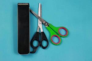 two scissors and a hair clipper on a blue background photo