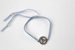 blue braded bracelet with chakra vishuddha on white background photo