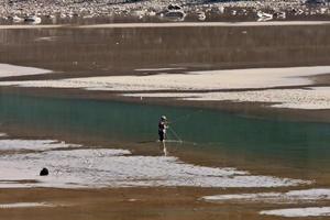 pescador con mosca en el lago de la medicina en el parque nacional jasper foto