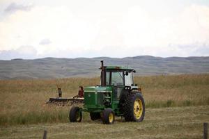 Tractor y hilera a la izquierda en un campo en el pintoresco Saskatchewan foto