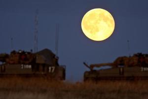 Armored vehicles under a full moon photo