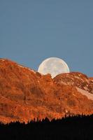 luna llena detrás de la montaña en la pintoresca alberta foto