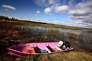 Pink boat in scenic Saskatchewan photo