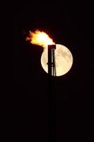 Full moon behind natural gas flame photo