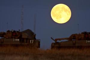 Armored vehicles under a full moon photo