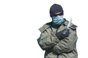 Special forces soldier in medical mask and knife in a hand on a white background photo