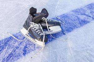 Sports black skates are on the hockey court. Winter Sports Equipment photo