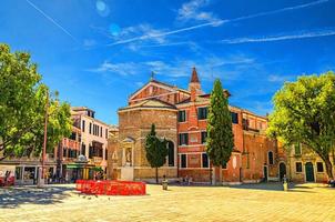 venecia, italia, 13 de septiembre de 2019 edificio de la iglesia católica chiesa rettoriale y árboles verdes en la plaza campo san polo foto