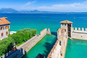 Small fortified harbor with turquoise water, Scaligero Castle Castello fortress in Sirmione