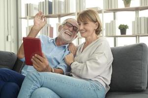 Caucasian happy seniors elderly are video calling to family or friends, relax at home, smiling healthy senior retired grandparents, older grandparent technology concept photo