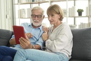 los ancianos caucásicos felices son videollamadas a familiares o amigos, se relajan en casa, sonríen abuelos jubilados sanos, concepto de tecnología de abuelos mayores foto