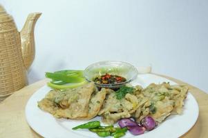 A traditional Javanese, Indonesian food made of tempeh coated with flour and half-fried green onions is called Tempe Mendoan photo