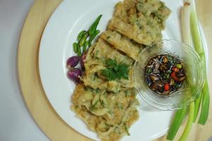 A traditional Javanese, Indonesian food made of tempeh coated with flour and half-fried green onions is called Tempe Mendoan photo