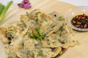 A traditional Javanese, Indonesian food made of tempeh coated with flour and half-fried green onions is called Tempe Mendoan photo