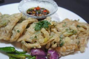 A traditional Javanese, Indonesian food made of tempeh coated with flour and half-fried green onions is called Tempe Mendoan photo