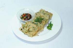 A traditional Javanese, Indonesian food made of tempeh coated with flour and half-fried green onions is called Tempe Mendoan photo