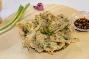 A traditional Javanese, Indonesian food made of tempeh coated with flour and half-fried green onions is called Tempe Mendoan photo