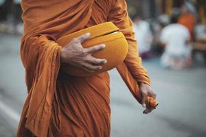 monje buda tailandés sosteniendo un tazón budista para recibir la ofrenda de comida de la mañana foto