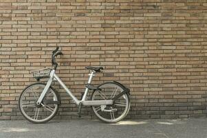 bicicleta retro en la carretera con fondo de pared de ladrillo vintage con espacio de copia. foto