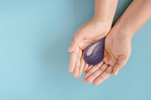 Water World CSR for Sustainable Lifestyles Concept, Save Water and Environment for Sustainable Resource. Female Hands Holding Water Drop Symbol on Isolate Blue Background. Sustainability Development photo