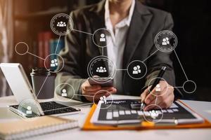 Social network theme hologram with businessman working on computer laptop, smartphone, and tablet with VR icons photo