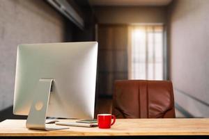 espacio de trabajo con computadora, computadora portátil, suministros de oficina y taza de café, teléfono inteligente y tableta en la oficina. concepto de trabajo de escritorio. en la luz de la mañana foto