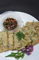 A traditional Javanese, Indonesian food made of tempeh coated with flour and half-fried green onions is called Tempe Mendoan photo