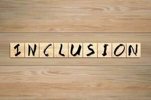 Inclusion word written on wood box. Text on wooden table. photo