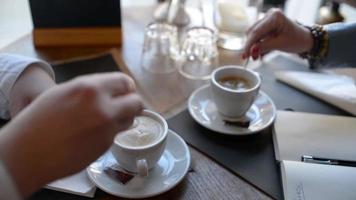 la gente pone azúcar en una taza de café en la mesa del restaurante video