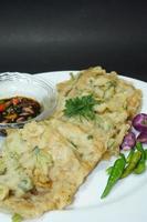 A traditional Javanese, Indonesian food made of tempeh coated with flour and half-fried green onions is called Tempe Mendoan photo