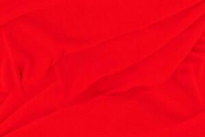 Red fabric texture background. Abstract cloth backdrop with soft waves. photo