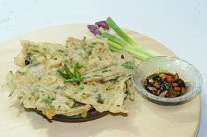 A traditional Javanese, Indonesian food made of tempeh coated with flour and half-fried green onions is called Tempe Mendoan photo