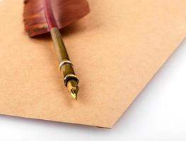 Old vintage burned envelope letter with quill feather pen isolated on a white background. photo