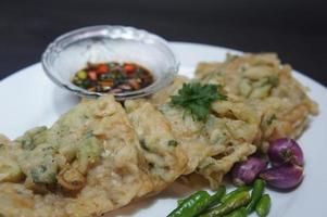 A traditional Javanese, Indonesian food made of tempeh coated with flour and half-fried green onions is called Tempe Mendoan photo