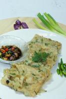 A traditional Javanese, Indonesian food made of tempeh coated with flour and half-fried green onions is called Tempe Mendoan photo