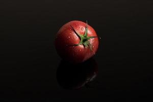 tomates en un fondo negro foto