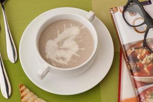 soup and a book on a green tablecloth photo