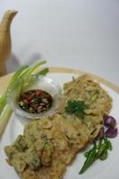 A traditional Javanese, Indonesian food made of tempeh coated with flour and half-fried green onions is called Tempe Mendoan photo