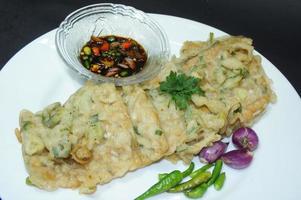 A traditional Javanese, Indonesian food made of tempeh coated with flour and half-fried green onions is called Tempe Mendoan photo