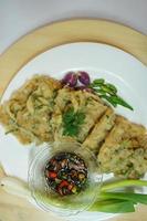 A traditional Javanese, Indonesian food made of tempeh coated with flour and half-fried green onions is called Tempe Mendoan photo