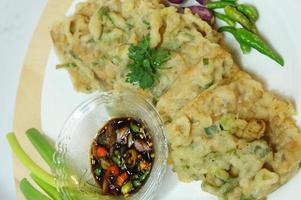 A traditional Javanese, Indonesian food made of tempeh coated with flour and half-fried green onions is called Tempe Mendoan photo